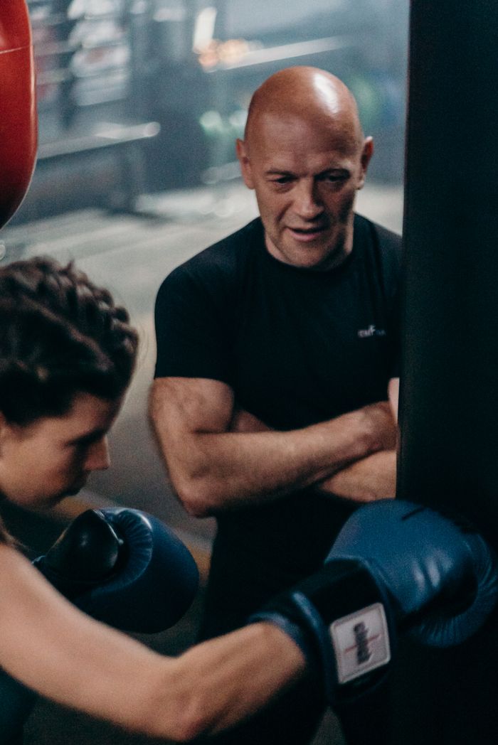 Crafting Captivating Headlines: Your awesome post title goes here Focused female boxer practicing punches under coach's supervision.