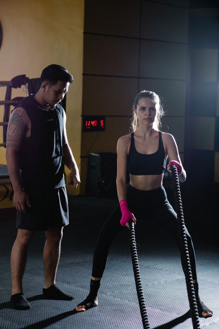 The Art of Drawing Readers In: Your attractive post title goes here Full body Latin American personal instructor helping active female in activewear exercising with battle ropes during intense training in gym
